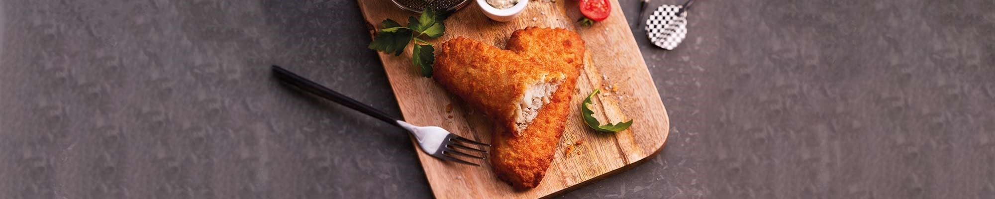 coated fish on wooden plate